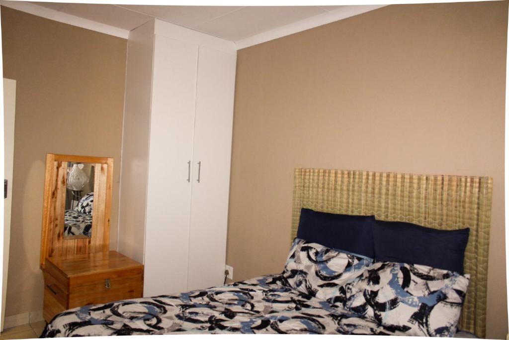 姆巴巴内City Centre Apartment的一间卧室配有一张床和镜子
