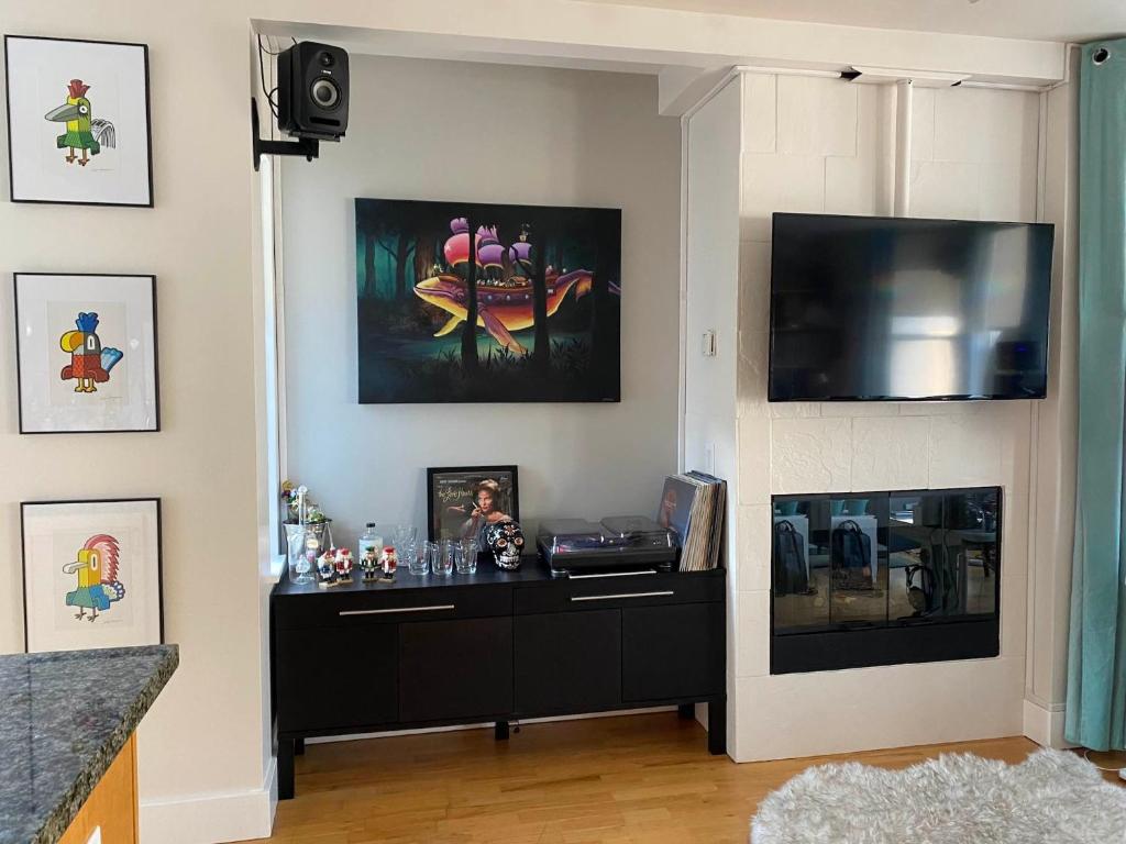 旧金山Modernstylish Nopa Penthouseremote Work Friendly的客厅配有黑色橱柜和平面电视。