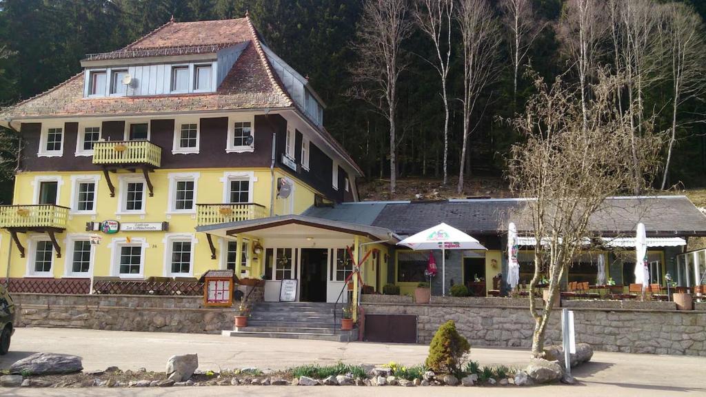 欣特察尔滕Gasthaus Hotel Löffelschmiede的黄色的大房子,设有门廊