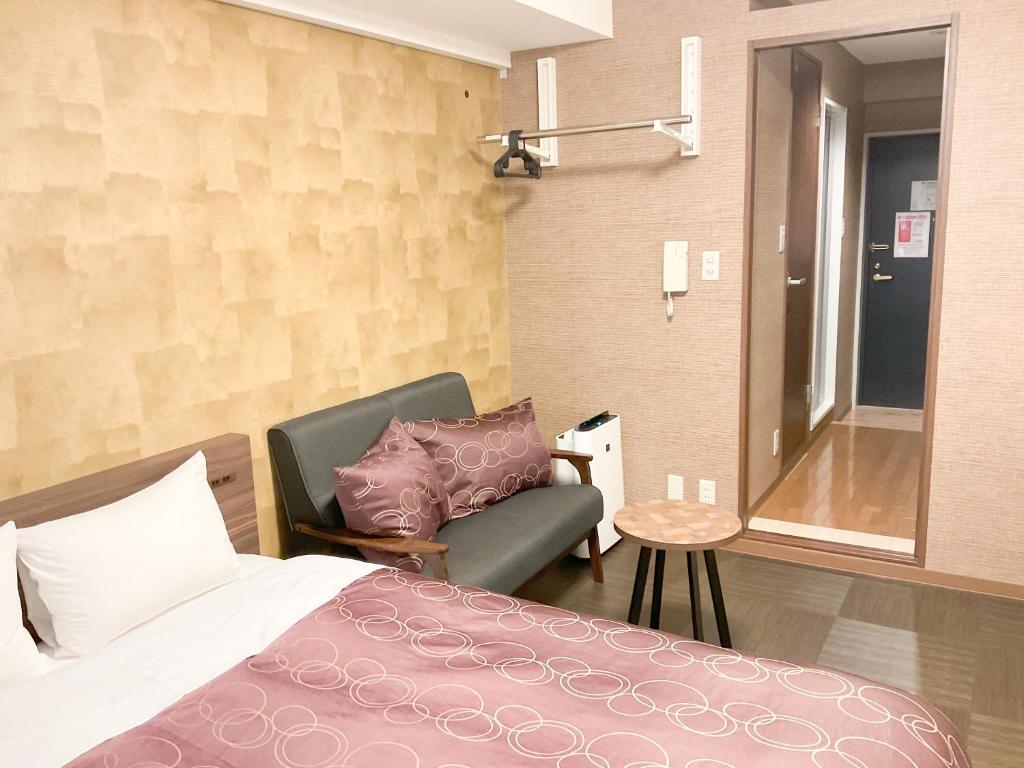 秩父市Comfort stay Miyabi的一间卧室配有一张床、一张沙发和一把椅子