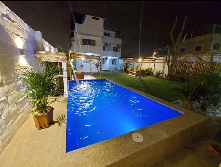 曼塔Mare S&M Casa Hostal的夜间在院子里的大型蓝色游泳池