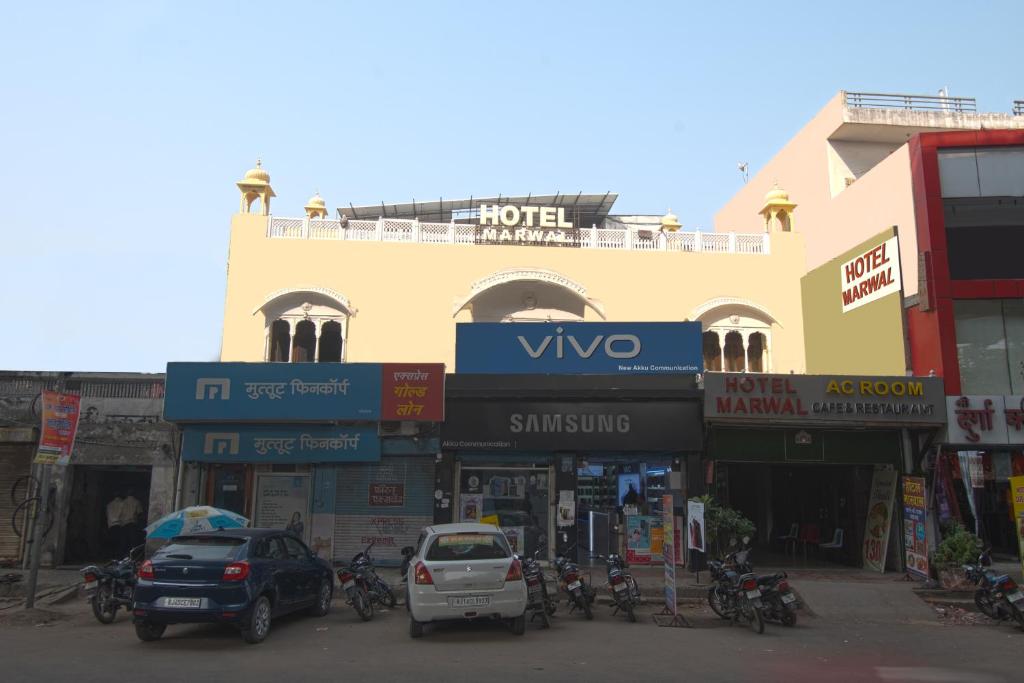 斋浦尔Hotel Marwal的一条在大楼前停放汽车的街道