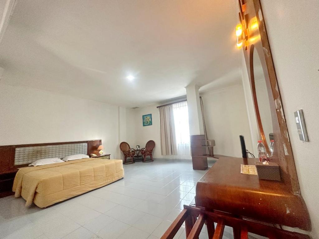 SibolgaHotel Wisata Indah Sibolga的一间卧室配有一张床、梳妆台和镜子