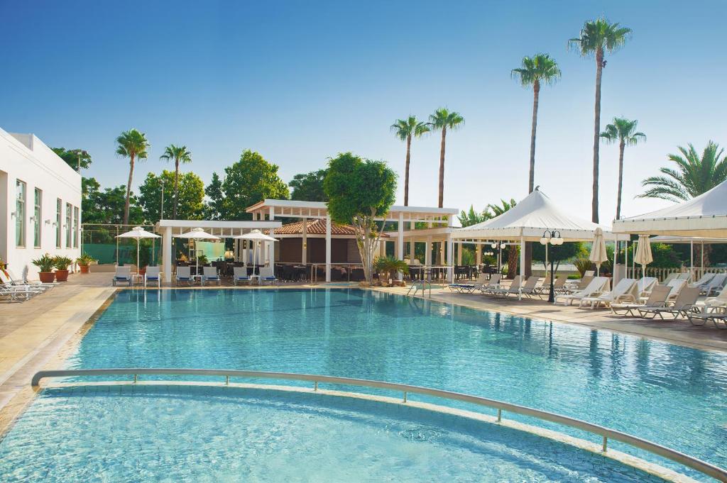 利马索尔阿贾克斯酒店的一个带椅子和棕榈树的大型游泳池