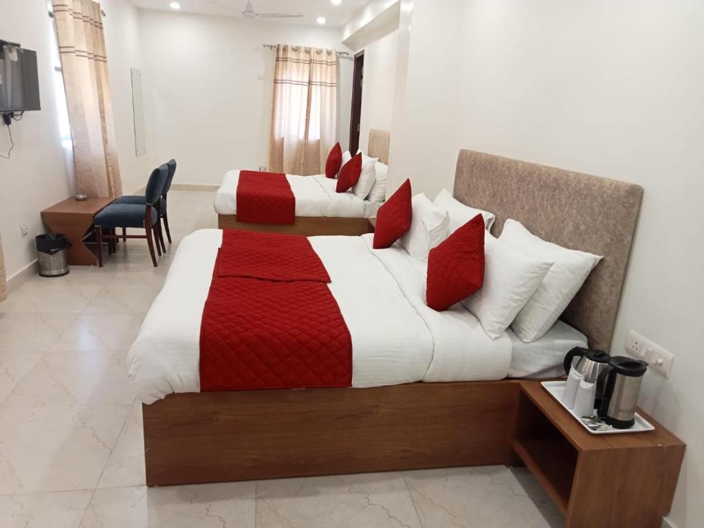 新德里Hotel Fortune Residency的酒店客房带两张红色和白色的床单