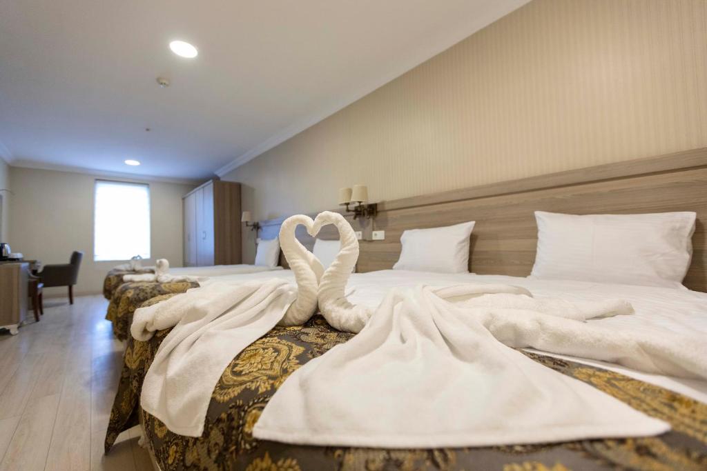 伊斯坦布尔World Point Hotel Besyol的两个天鹅坐在酒店房间两张床上