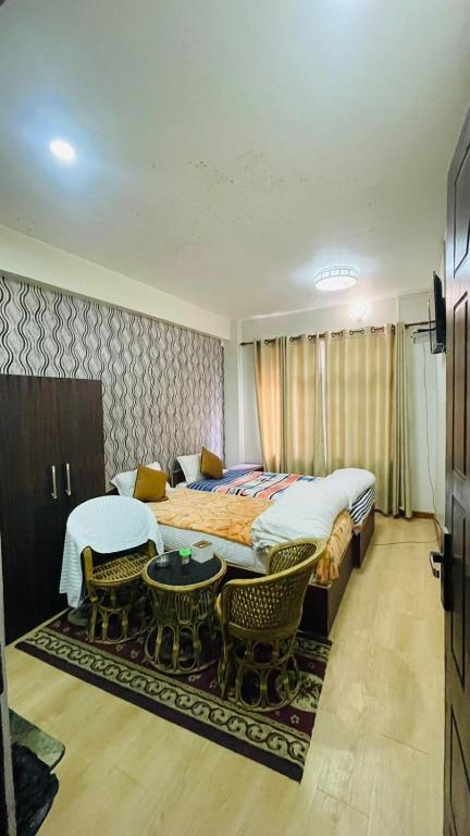 图利凯尔Hotel peace point dhulikhel的一间卧室配有一张大床和一张桌子及椅子
