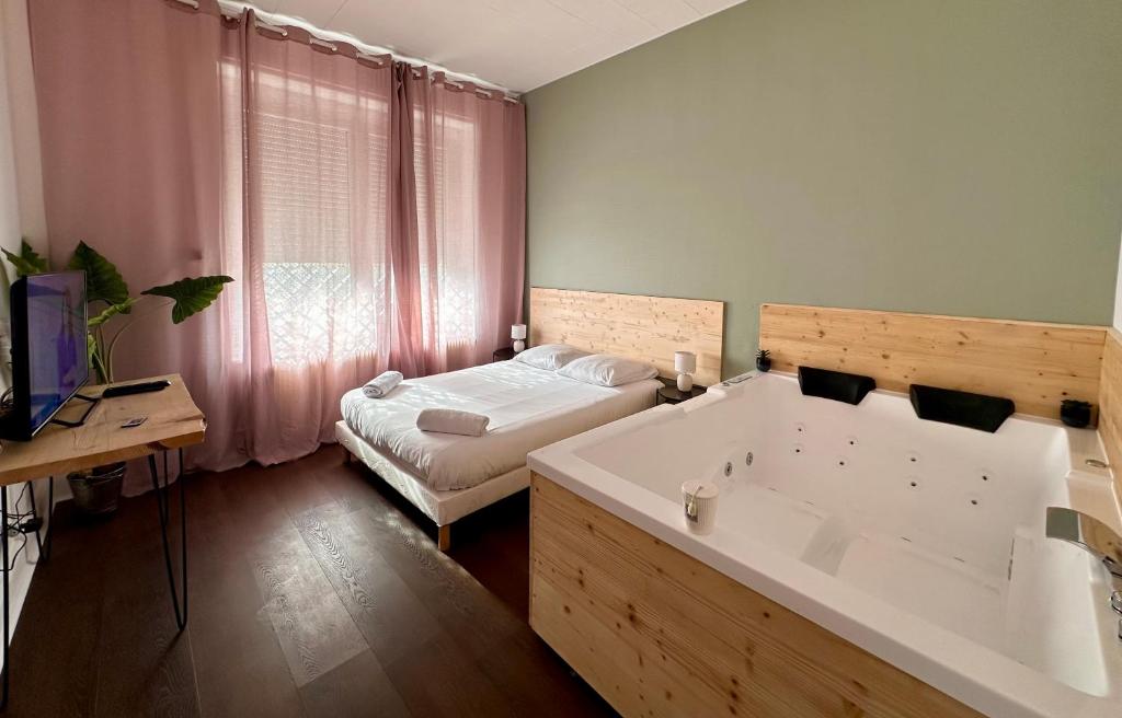 南希A0 Grand Appartement, Jaccuzi, et extérieur Thermal Artem à 200m的一间带浴缸的浴室和一张位于客房内的床