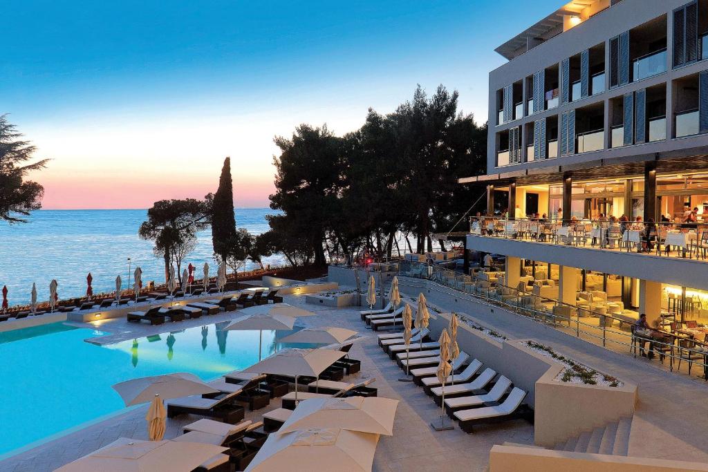 波雷奇帕林提姆蓝色泻湖酒店的酒店拥有带躺椅的游泳池和海洋