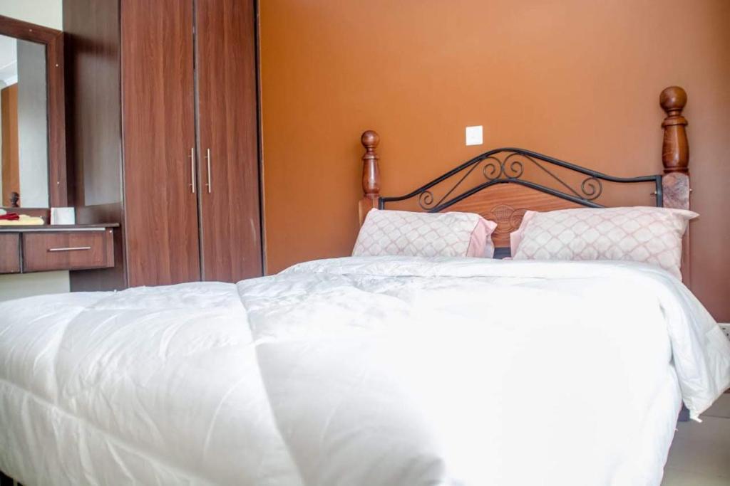 蒙巴萨Sp Accommodations的卧室内的一张带白色床单和枕头的床