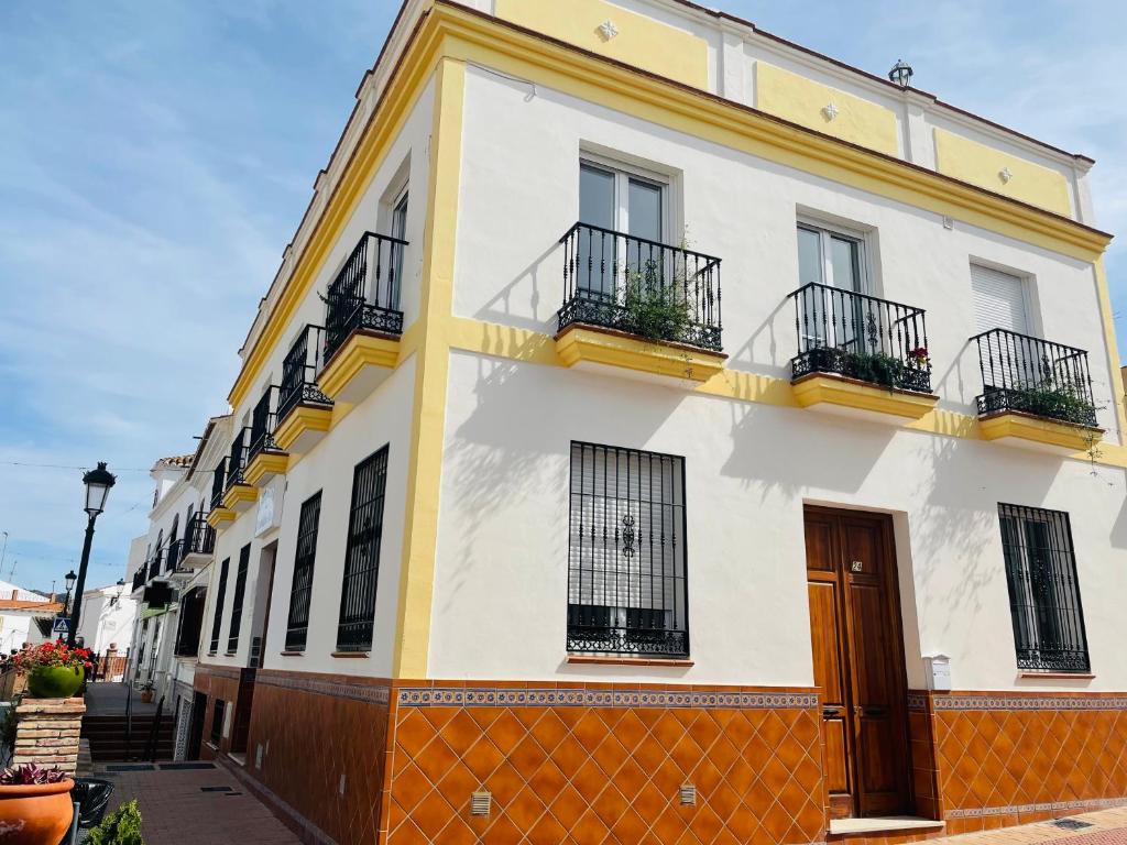 马罗Acantilados De Maro的黄色和白色的建筑,在街上设有阳台