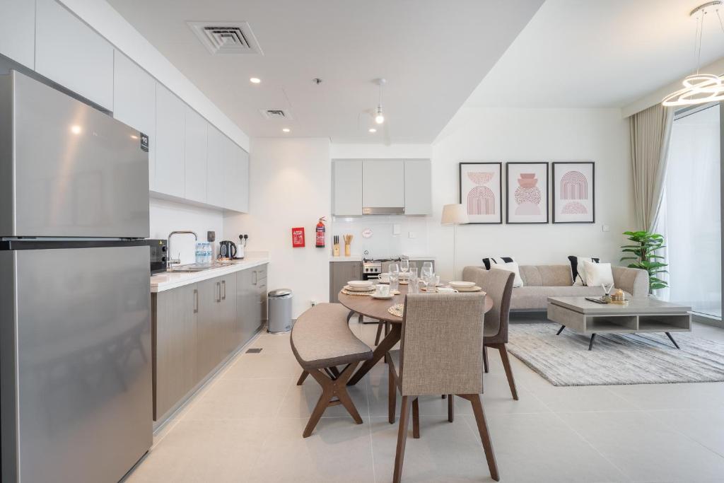 迪拜Heaven Crest Holiday Homes - Luxury Forte的厨房以及带桌椅的起居室。