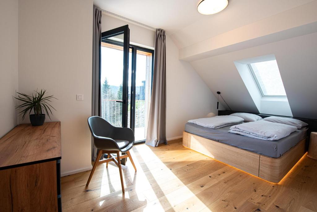 扬斯凯拉兹涅Ski&Bike horský apartmán 502的一间卧室配有一张床、一张桌子和一把椅子