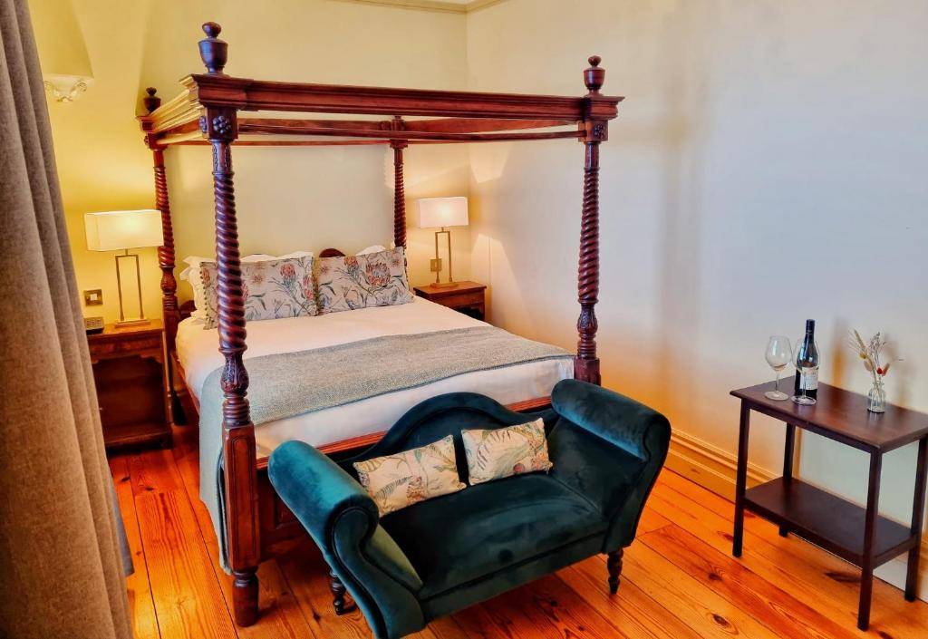 韦克斯福德Newbay House Wexford的一间卧室配有天蓬床和绿椅
