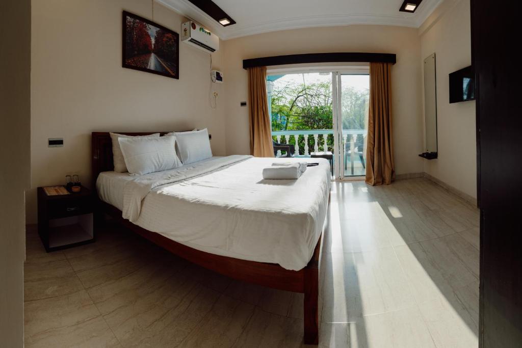 卡兰古特Tony's beach house的一间卧室设有一张大床和一个大窗户