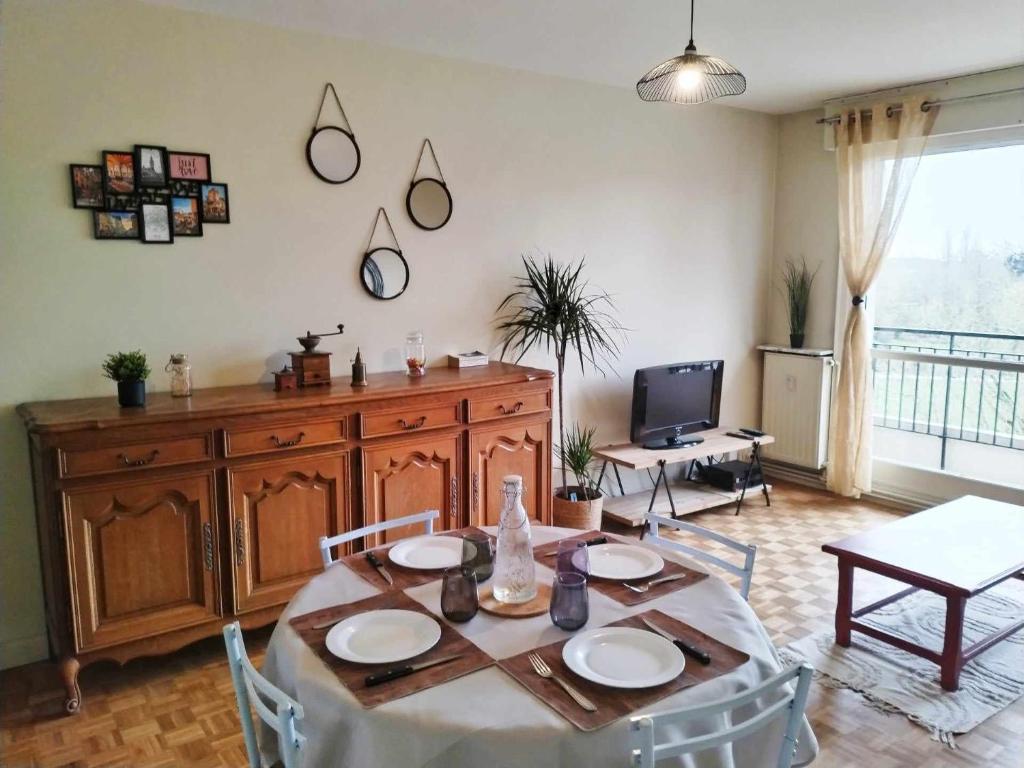 鲁贝Appartement Barbieux - Roubaix - 15min de Lille的客厅配有桌子和电视