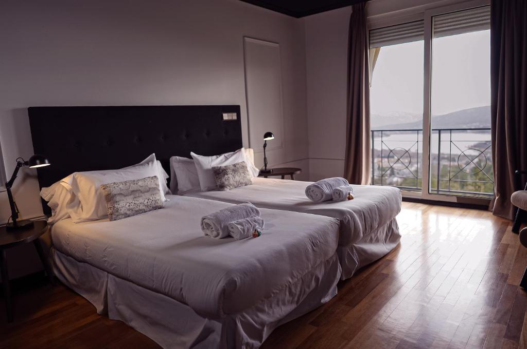 纳瓦塞拉达Hotel Arcipreste de Hita - Adults Only的一间卧室配有一张大床和毛巾