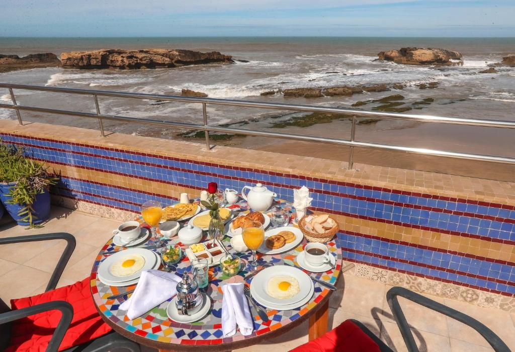 索维拉Riad Perle D'Eau的阳台上的一张桌子,早餐在阳台上,享有海景。