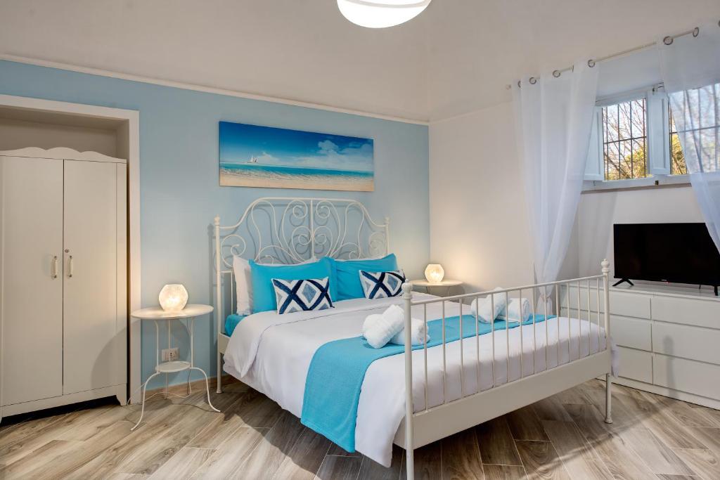 皮雅诺迪索伦托Il giardino di aranci e limoni的蓝色和白色的卧室设有1张床和1台电视