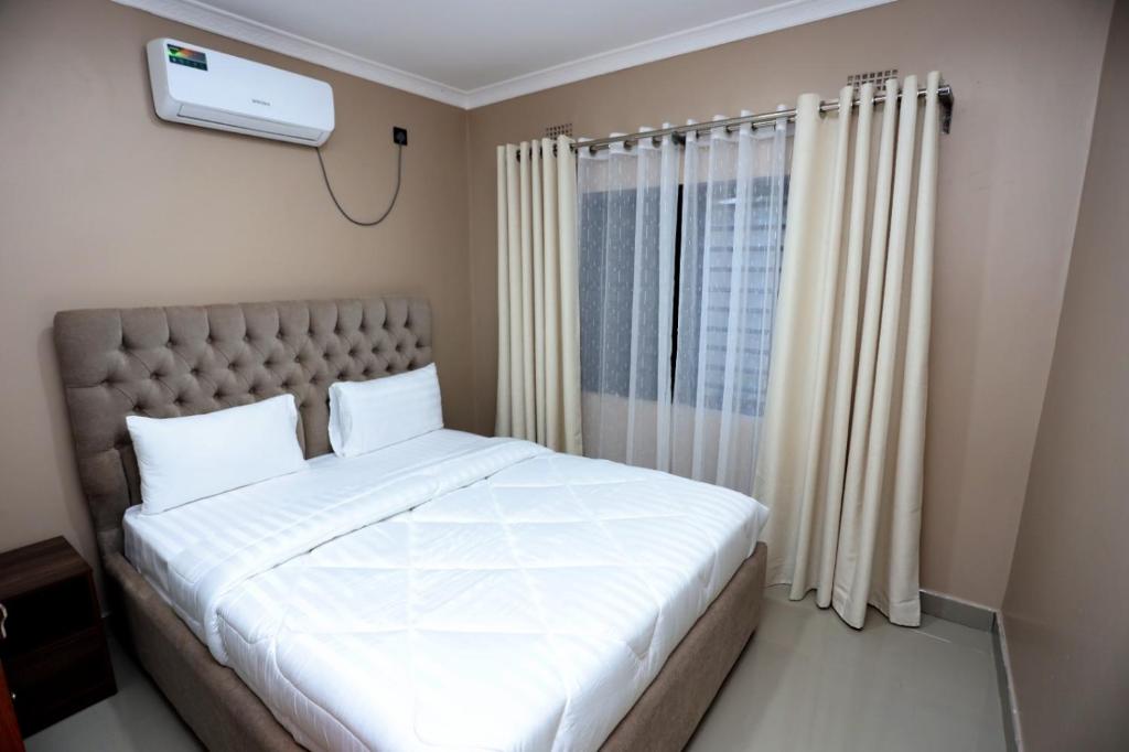 KitweCloud One Apartments的卧室设有一张白色大床和一扇窗户。