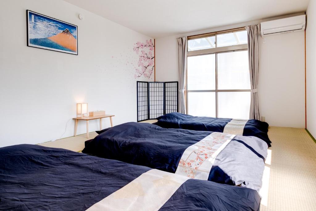 松本Forest Agata的卧室设有两张床,带窗户