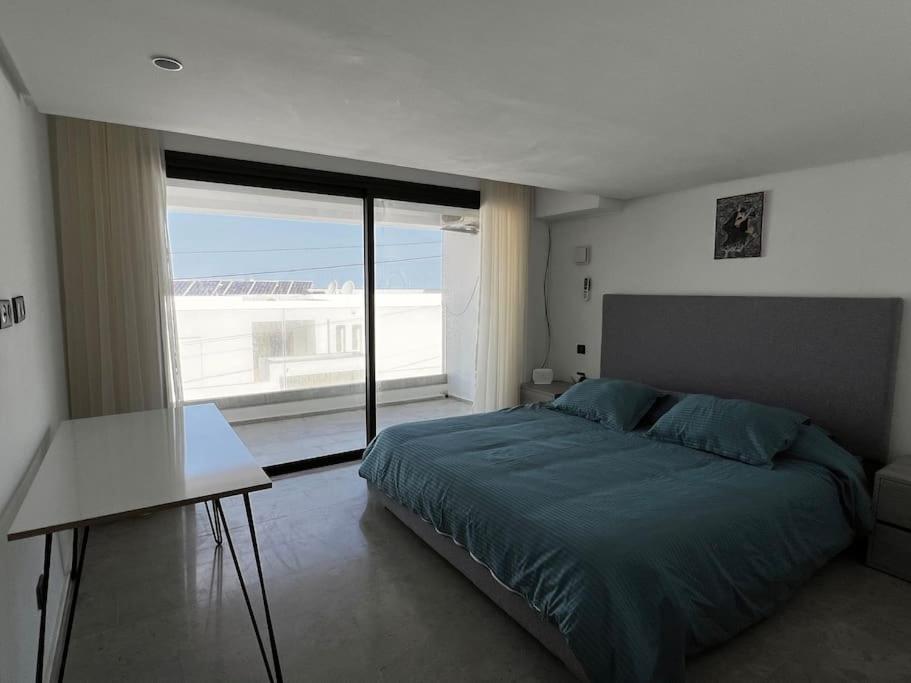 比塞大Duplex Blue Lagoon的一间卧室设有一张床和一个大窗户