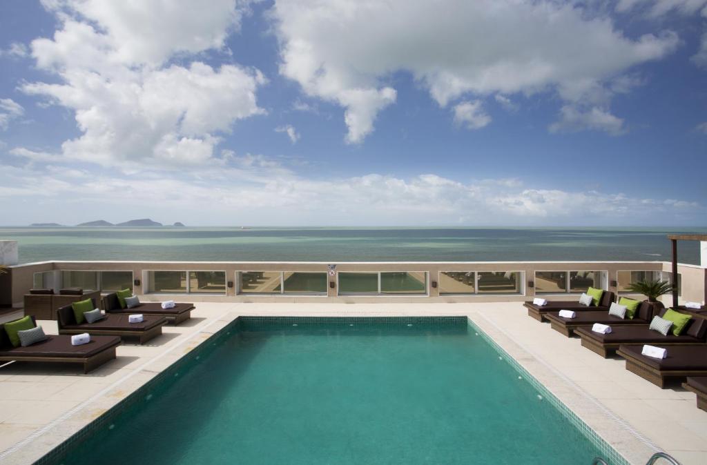 马卡埃皇家亚特兰大马卡埃酒店的一座带椅子的建筑顶部的游泳池,大海