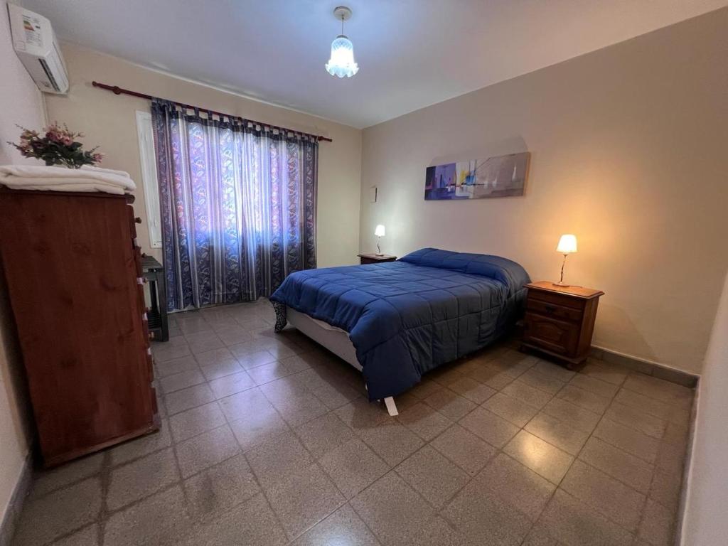 圣萨尔瓦多德朱Casa Felisa的一间卧室设有蓝色的床和窗户。