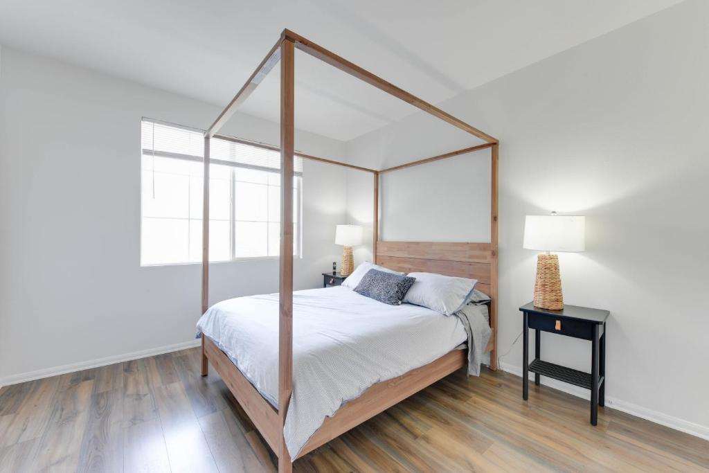 洛杉矶Spacious, Comfortable, and Central Condo的一间卧室设有一张天蓬床和木地板。