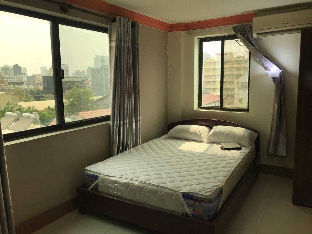 金边RS Galaxy HOTEL的一张小床,位于带两个窗户的房间