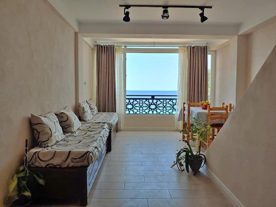 贝贾亚Appartement T2 avec terrasse et Vue mer à Béjaïa proche plage的带沙发和大窗户的客厅