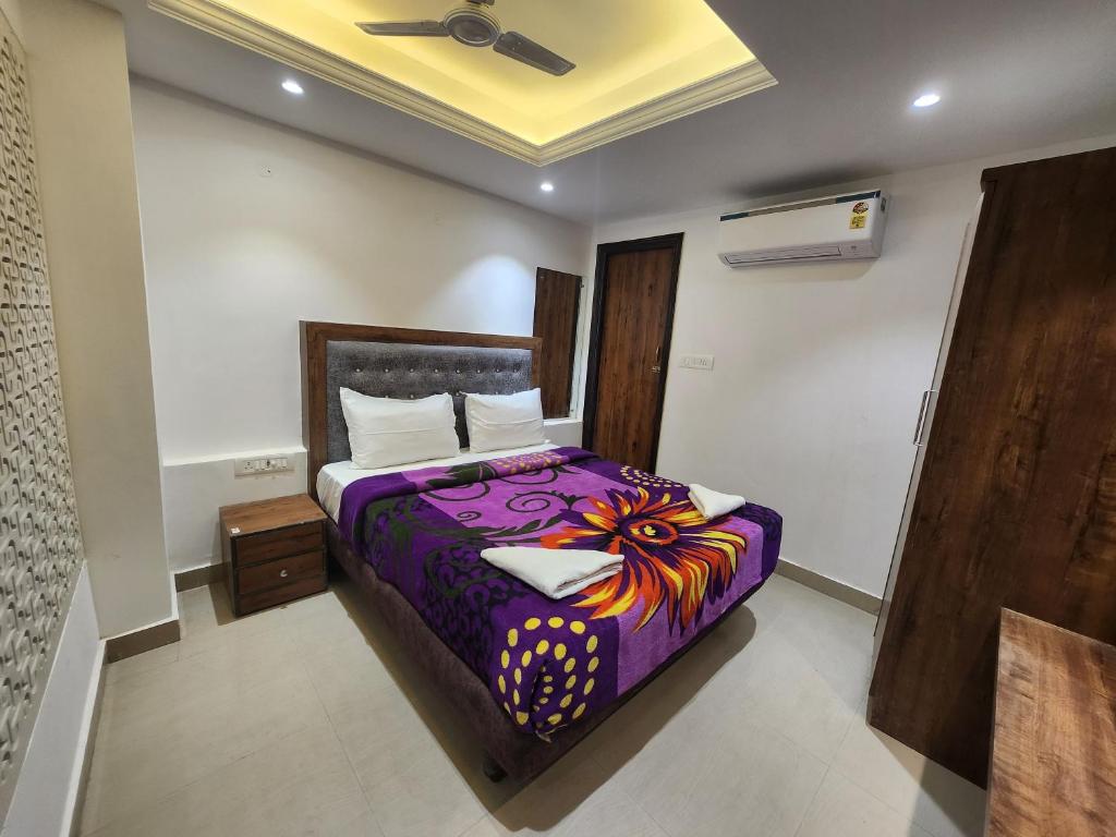 戈勒克布尔HOTEL SAI PALACE的一间卧室配有一张带紫色棉被的床