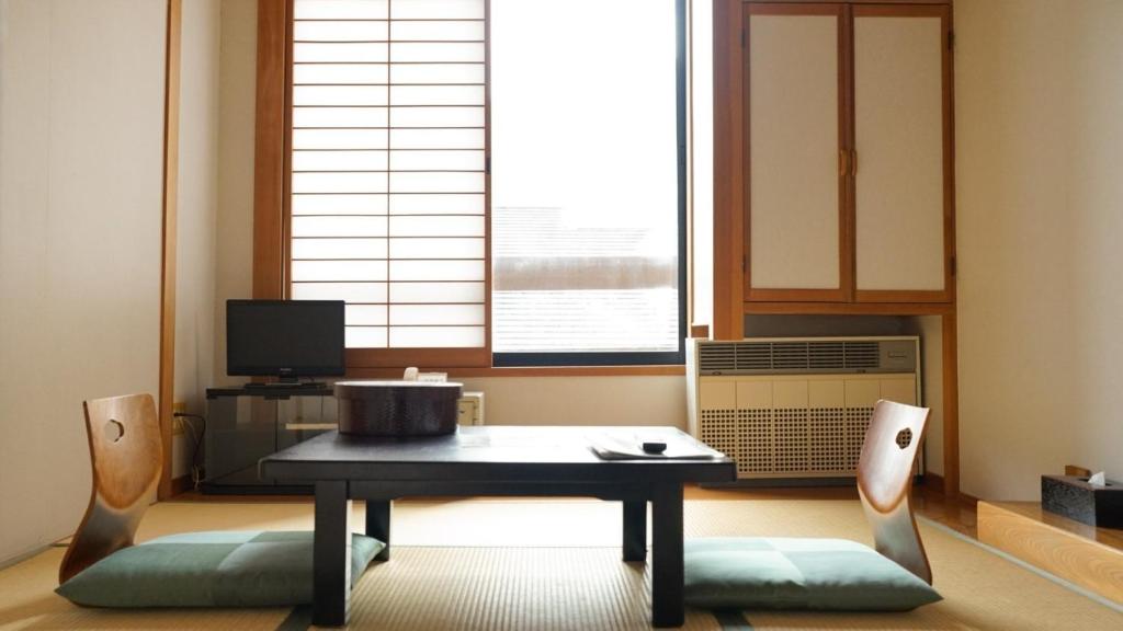 松本Nakanoyu Onsen Ryokan - Vacation STAY 18824v的客厅配有桌椅和窗户。