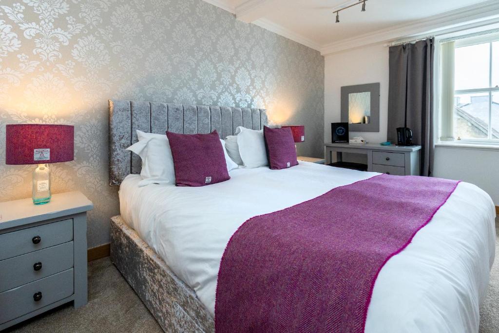 斯托诺韦Stornoway Bed and Breakfast的一间卧室配有一张大床和紫色毯子