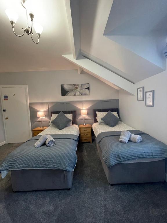 凯西克Rivendell Guest House的配有2张单人床的客房,配有2盏灯