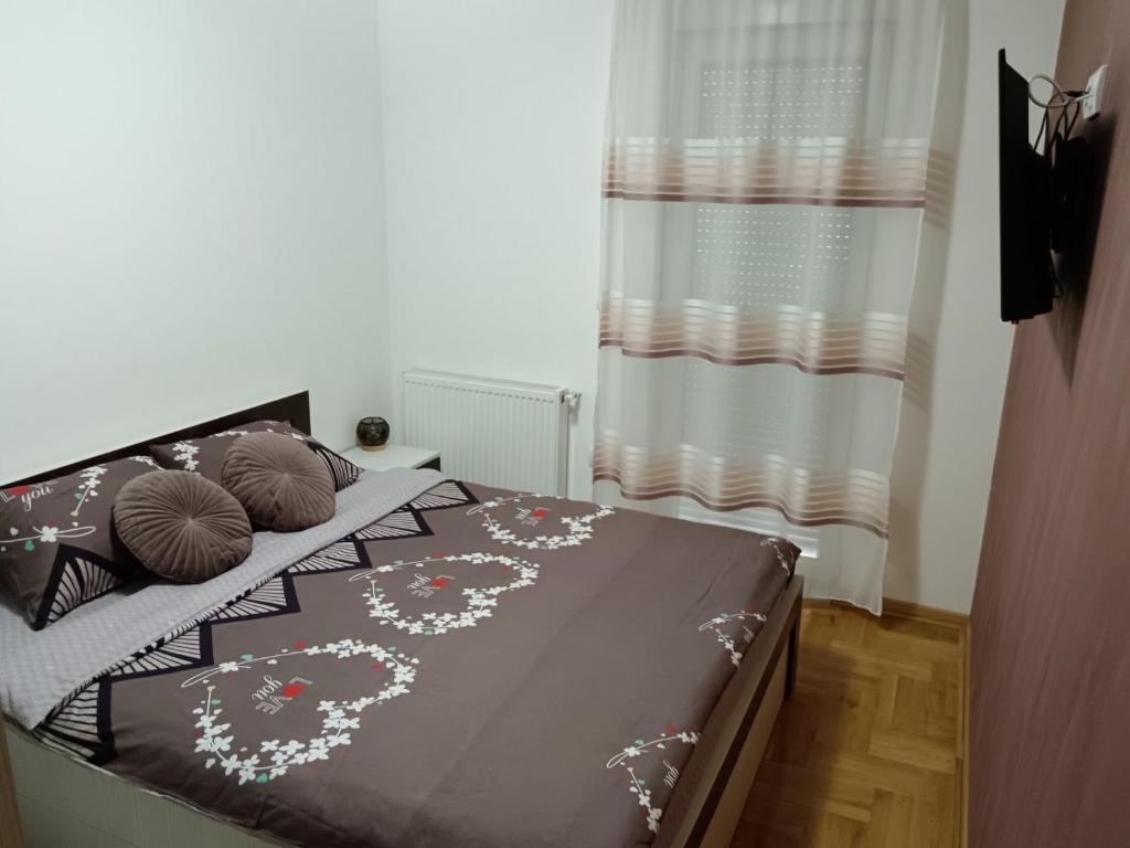 VrnjciApartman Jasna的一间卧室配有一张带棕色毯子和枕头的床。
