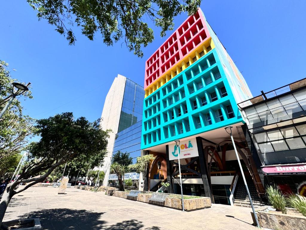 瓜达拉哈拉Hotel Olá Chapultepec的一座高大的建筑,有色彩缤纷的窗户,位于城市