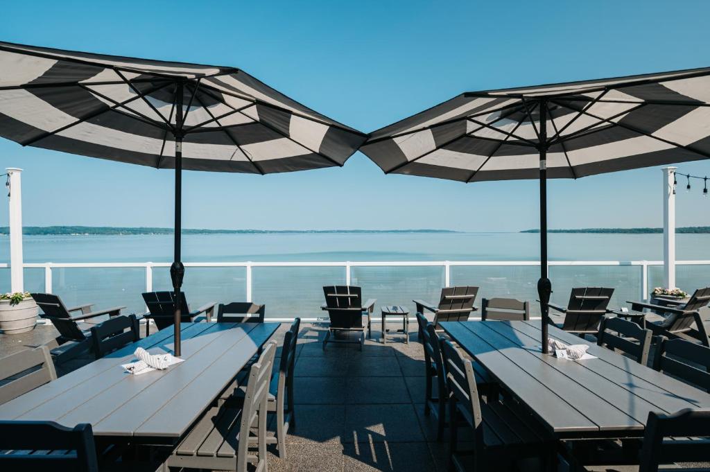 特拉弗斯城Alexandra Inn的海滩上的两张桌椅和遮阳伞