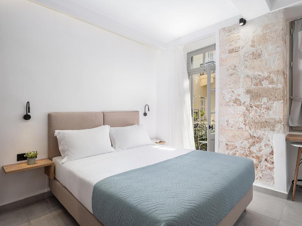 干尼亚Porto Vecchio的白色的卧室设有一张大床和一个窗户