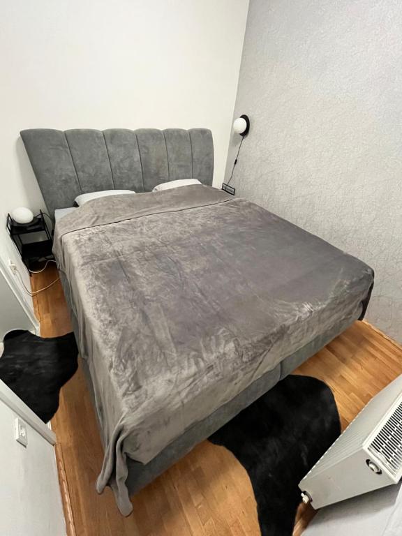 大戈里察APARTMAN 4U Velika Gorica near Zagreb Airport的一间卧室配有一张带灰色毯子的大床