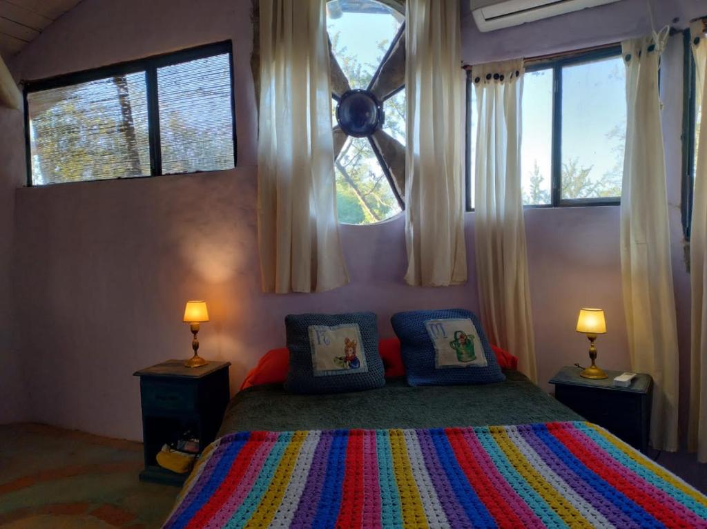圣哈维尔CasaIsolina的一间卧室配有一张带两盏灯的床和两扇窗户。