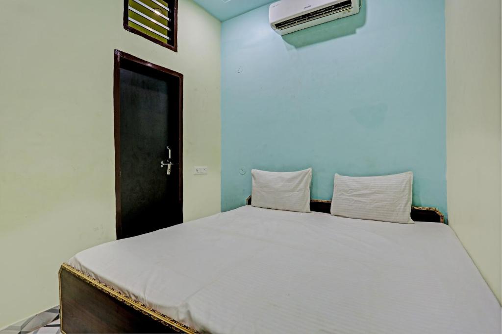 Garhi HarsāruOYO D Ekant Hotel的卧室配有一张白色大床和黑色门
