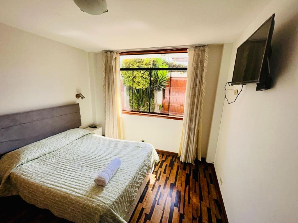 塔克纳Villa Salluzzi Apart Hotel的一间小卧室,配有床和窗户