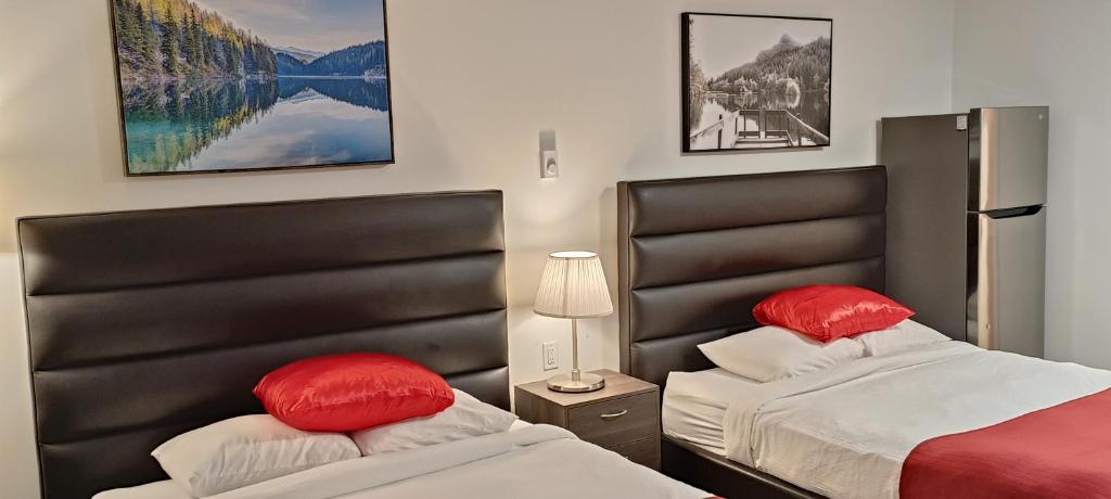 霍普Mountain View Hope Motel的客房内的两张床和红色枕头
