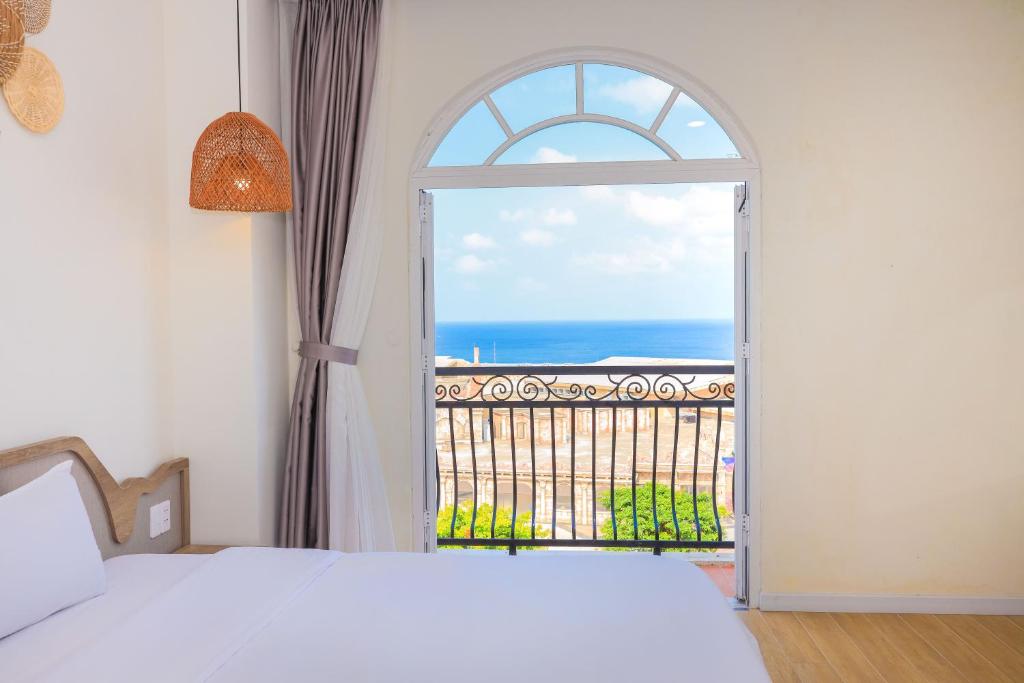 富国Lily House Hotel Phu Quoc的卧室设有窗户,享有海景