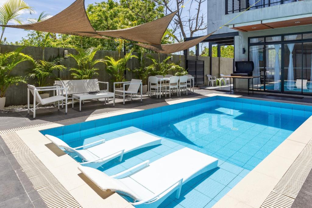 MaribagoISLA VILLA 2 Luxury Pool Villa near beach with karaoke video games barbecue的一个带椅子和桌子的室外游泳池