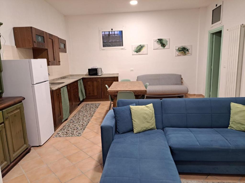 菲纳莱利古雷Casa Rosa的一间带蓝色沙发的客厅和一间厨房