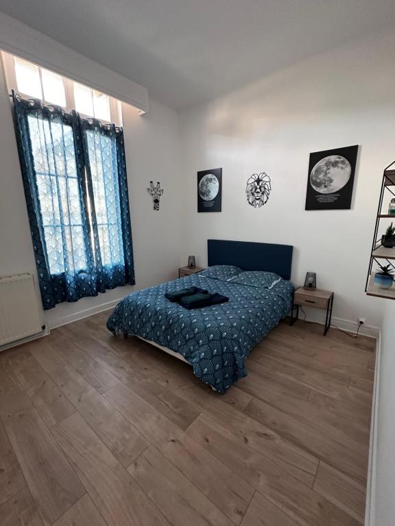 欧塞尔L évasion centre ville famille的一间卧室配有一张床,铺有木地板