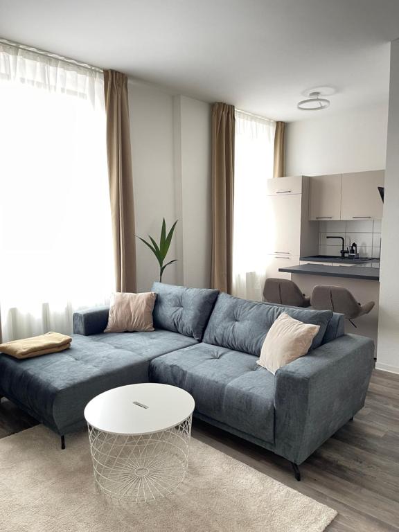 阿尔滕堡Moderne und stilvolle Wohnung direkt am Teich的客厅配有蓝色的沙发和桌子