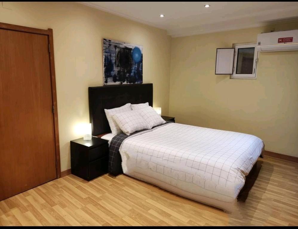 里斯本Apartamento acolhedor no coração de Lisboa的一间卧室配有一张白色大床和床头柜